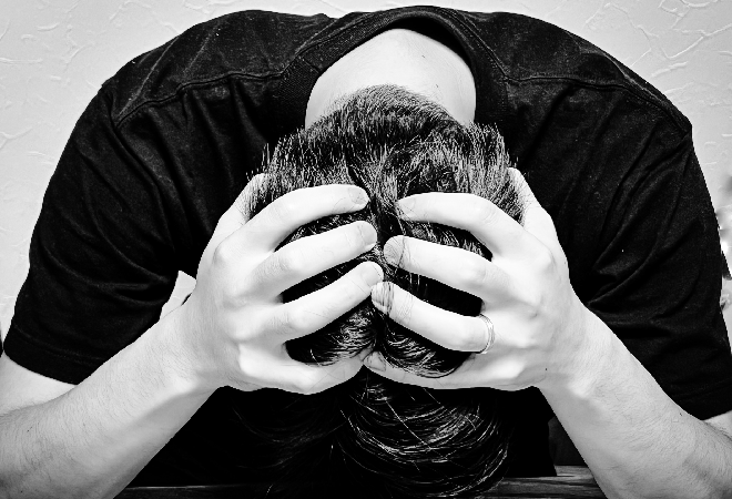 頭を抱える男性の写真。