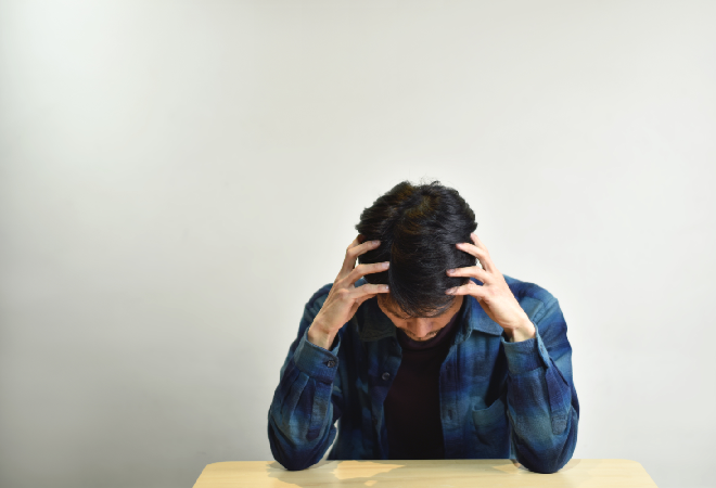 頭を抱える男性。
