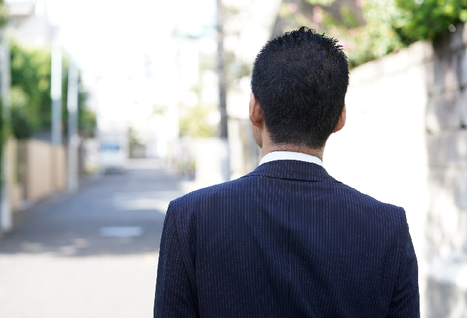 スーツ姿の男性の背中。