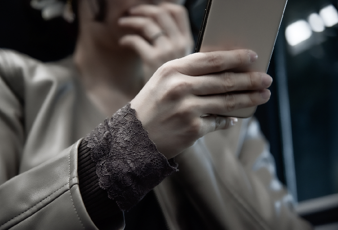 スマホを見てショックを受ける女性。