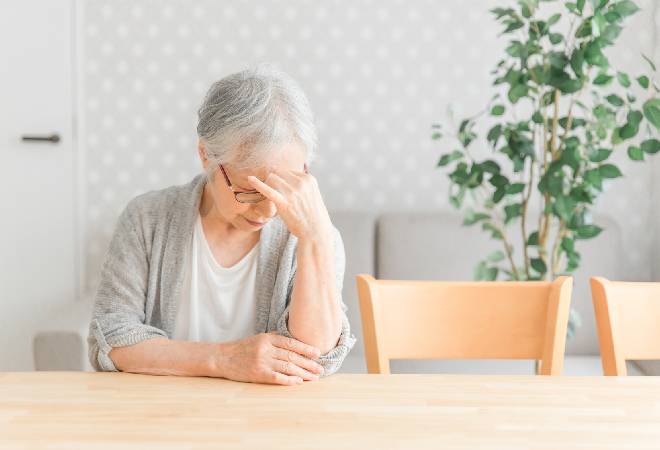 悩む高齢女性の姿。