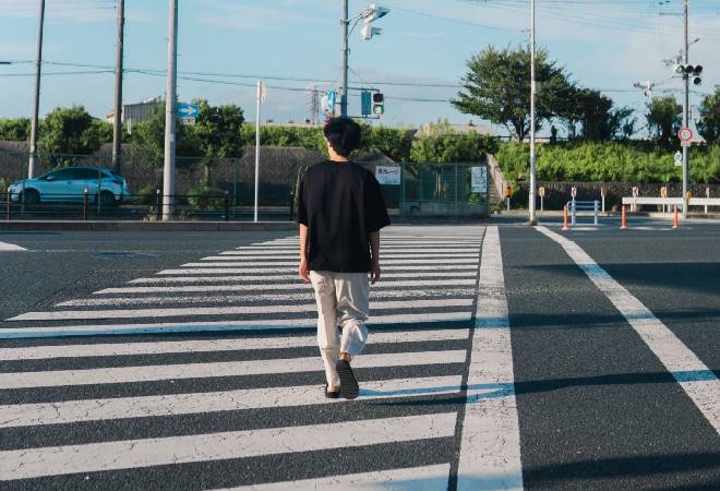 横断歩道を渡る若者の後ろ姿。