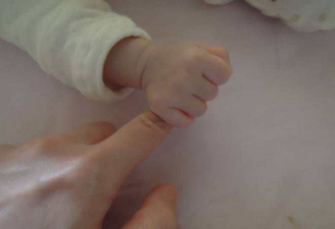 母親の指を握る赤ん坊の手。