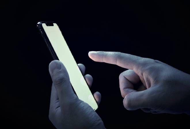 暗がりの中で光るスマホ。