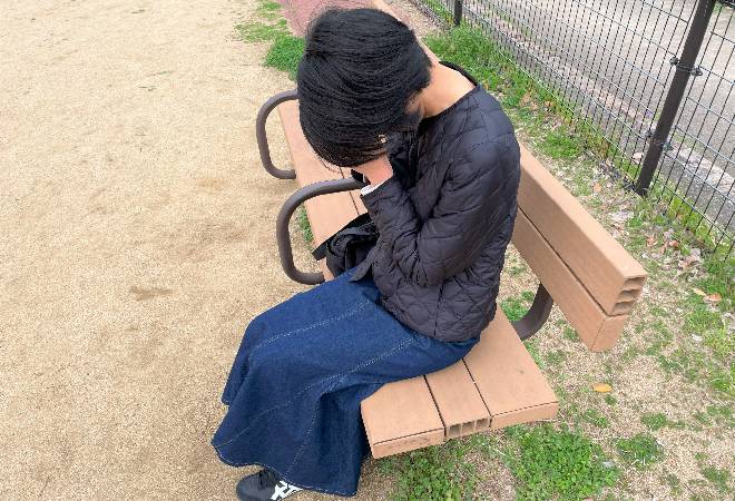 公園で落ち込む女性の姿。