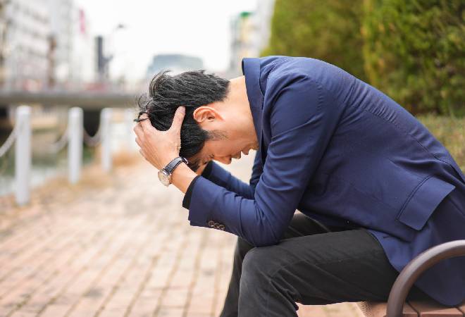 頭を抱える男性の姿。